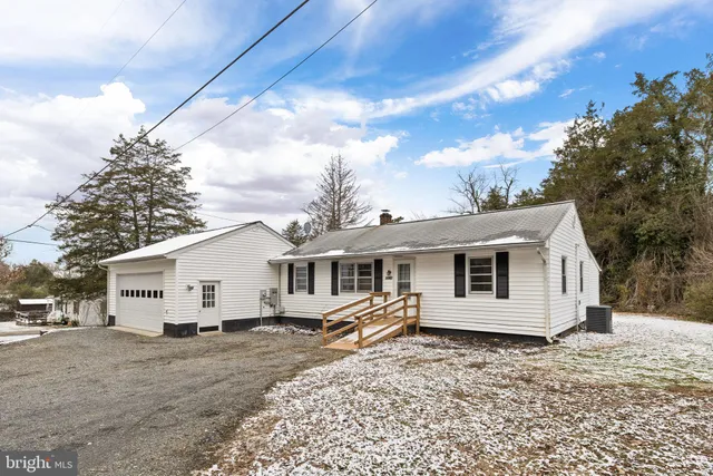 a view of a white house with a big yard and large trees