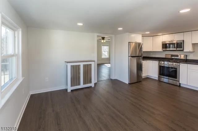 a view of kitchen with stainless steel appliances granite countertop a refrigerator and a stove top oven