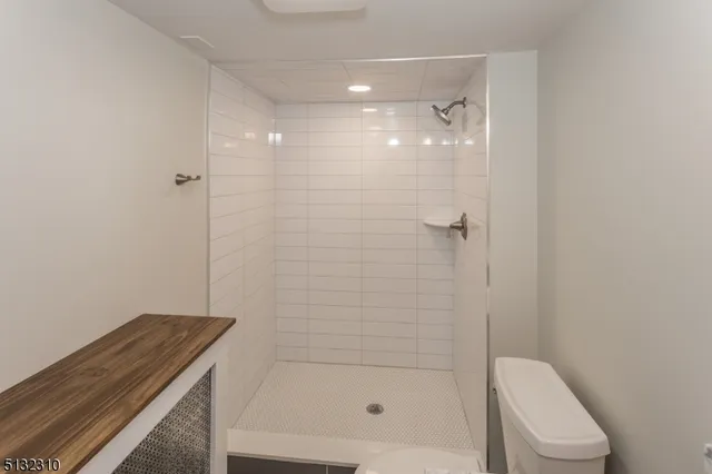 a bathroom with a granite countertop bathtub shower and toilet