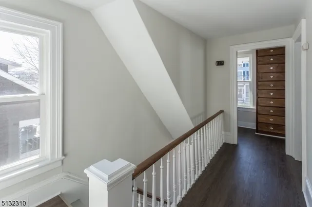 a view of a hallway with wooden floor and stairs
