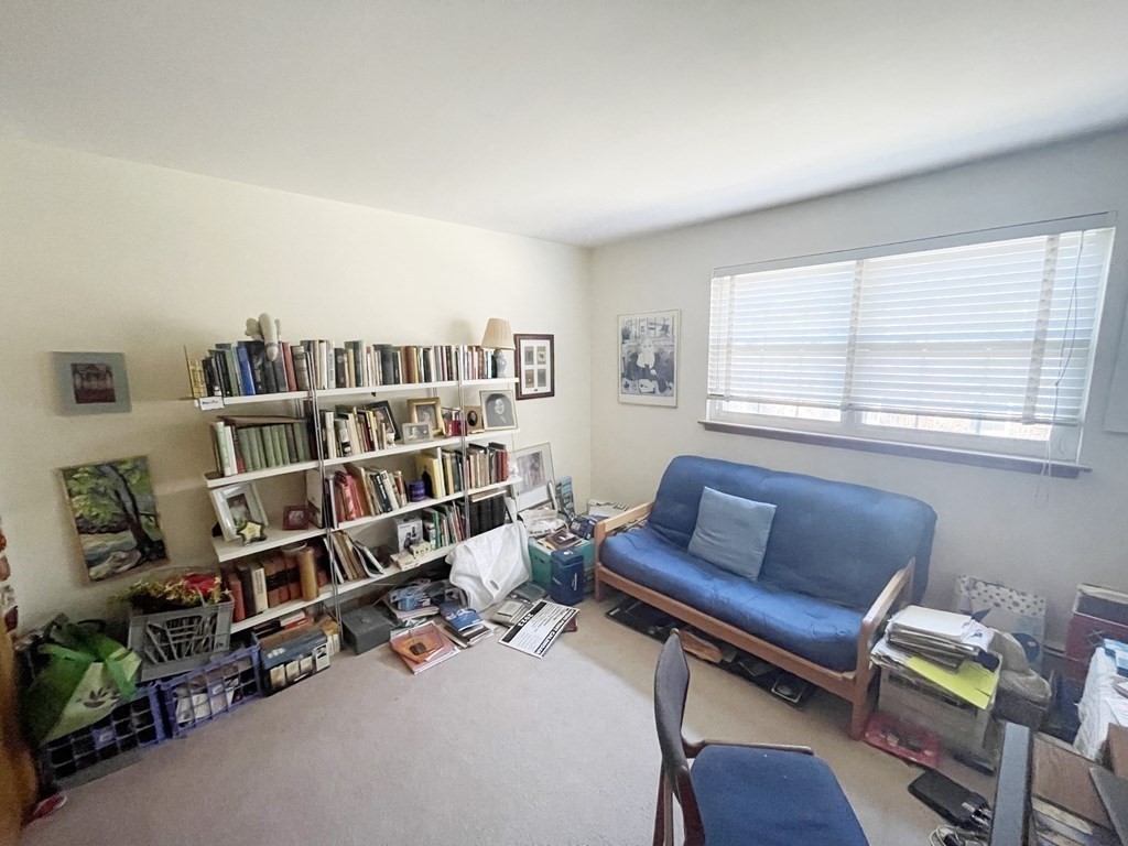 55 Jacqueline Road, Unit 7 Waltham, MA 02452 - Photo 8 of 11 a living room with furniture and a book shelf