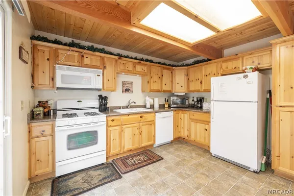 a kitchen with granite countertop a stove sink and cabinets