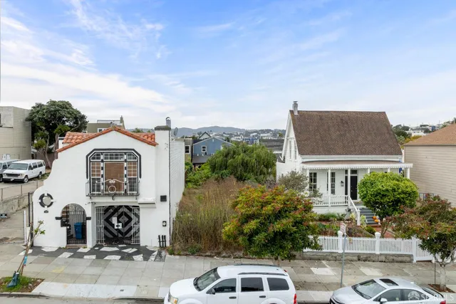 an aerial view of a house with garden space and a car park