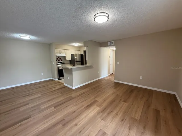 a view of a kitchen with wooden floor and electronic appliances