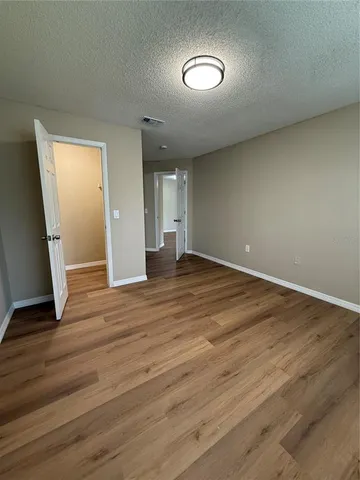 an empty room with wooden floor and mirror