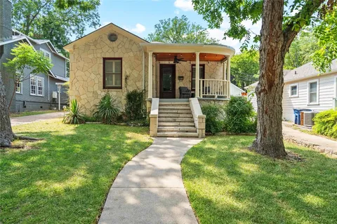 a front view of a house with a yard and trees