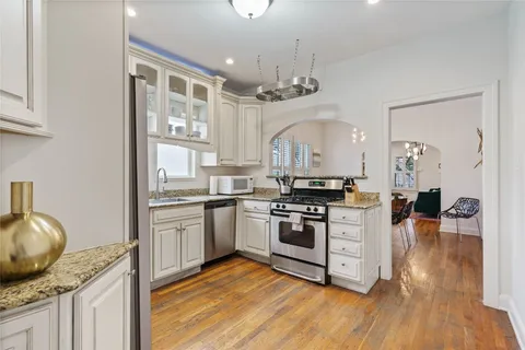 a kitchen with granite countertop a stove and cabinets
