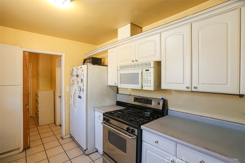4331 Maxson Road El Monte, CA 91732 - Photo 10 of 32 a kitchen with a stove a refrigerator and cabinets