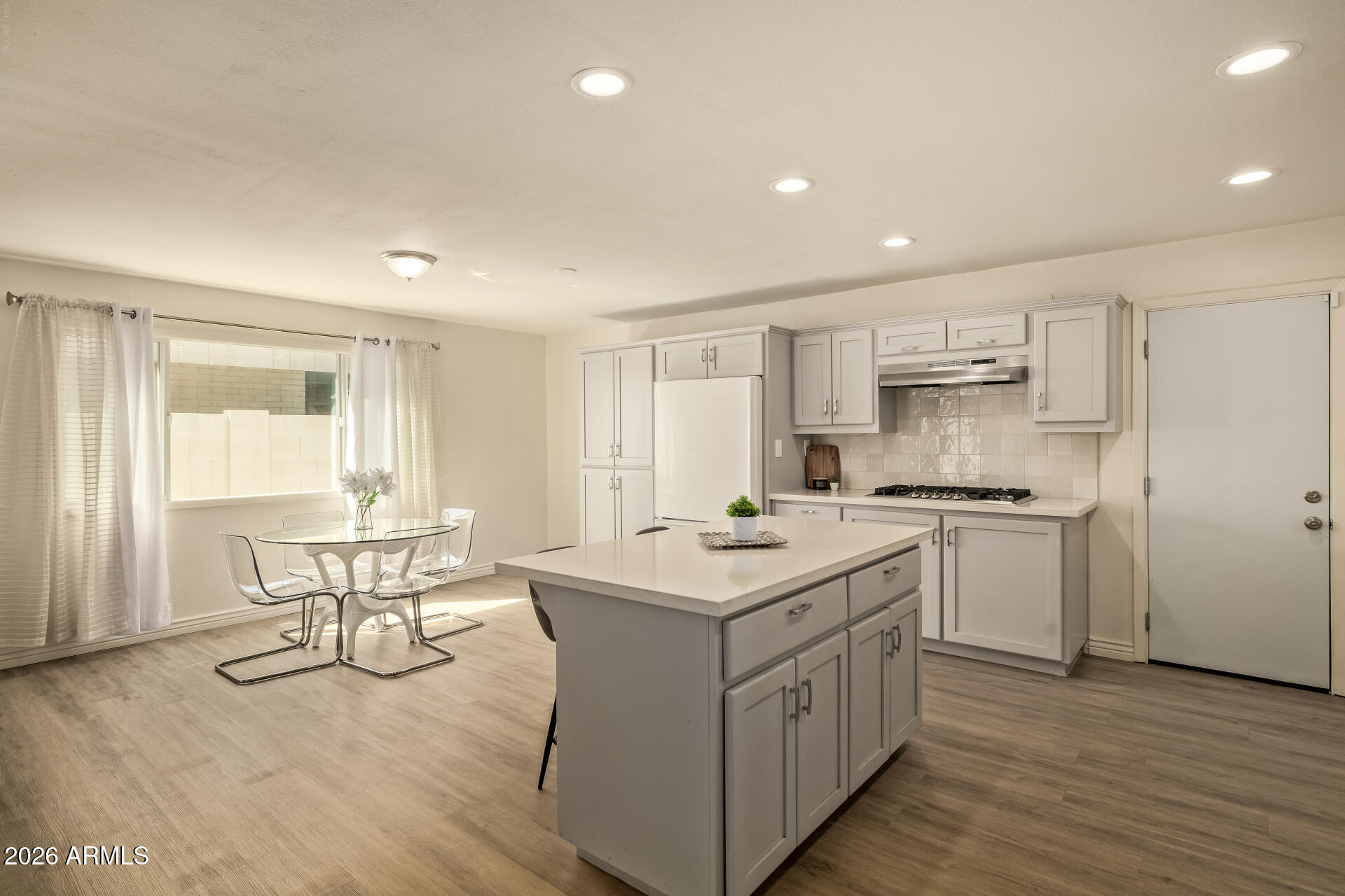 3101 West Shangri-la Road Phoenix, AZ 85029 - Photo 16 of 37 a kitchen with a sink stove and white cabinets with wooden floor