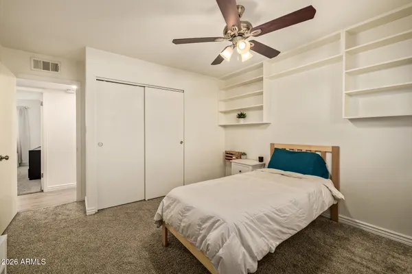 a bedroom with a bed and a ceiling fan