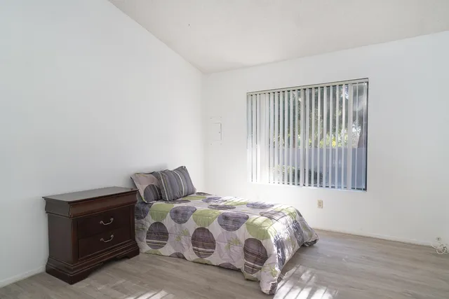 a view of a bedroom with wooden floor