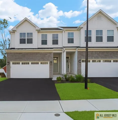 a front view of a house with a yard and trees