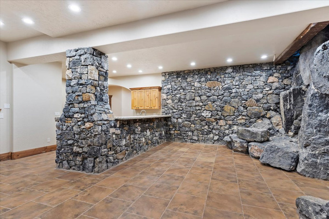 246 Woods Creek Road Morgan, UT 84050 - Photo 63 of 69 Stone accent wall and column, built-in wet bar with wood cabinetry, recessed lighting, and large format tile flooring