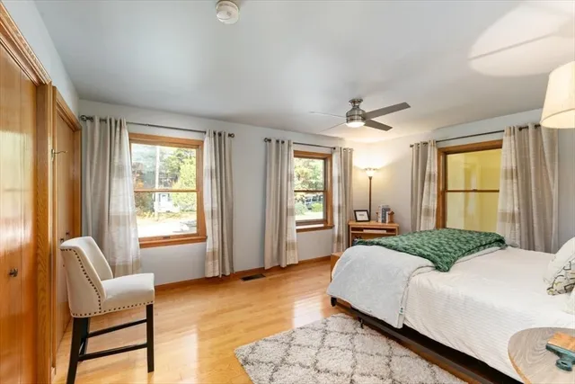 a view of an empty room with wooden floor and windows