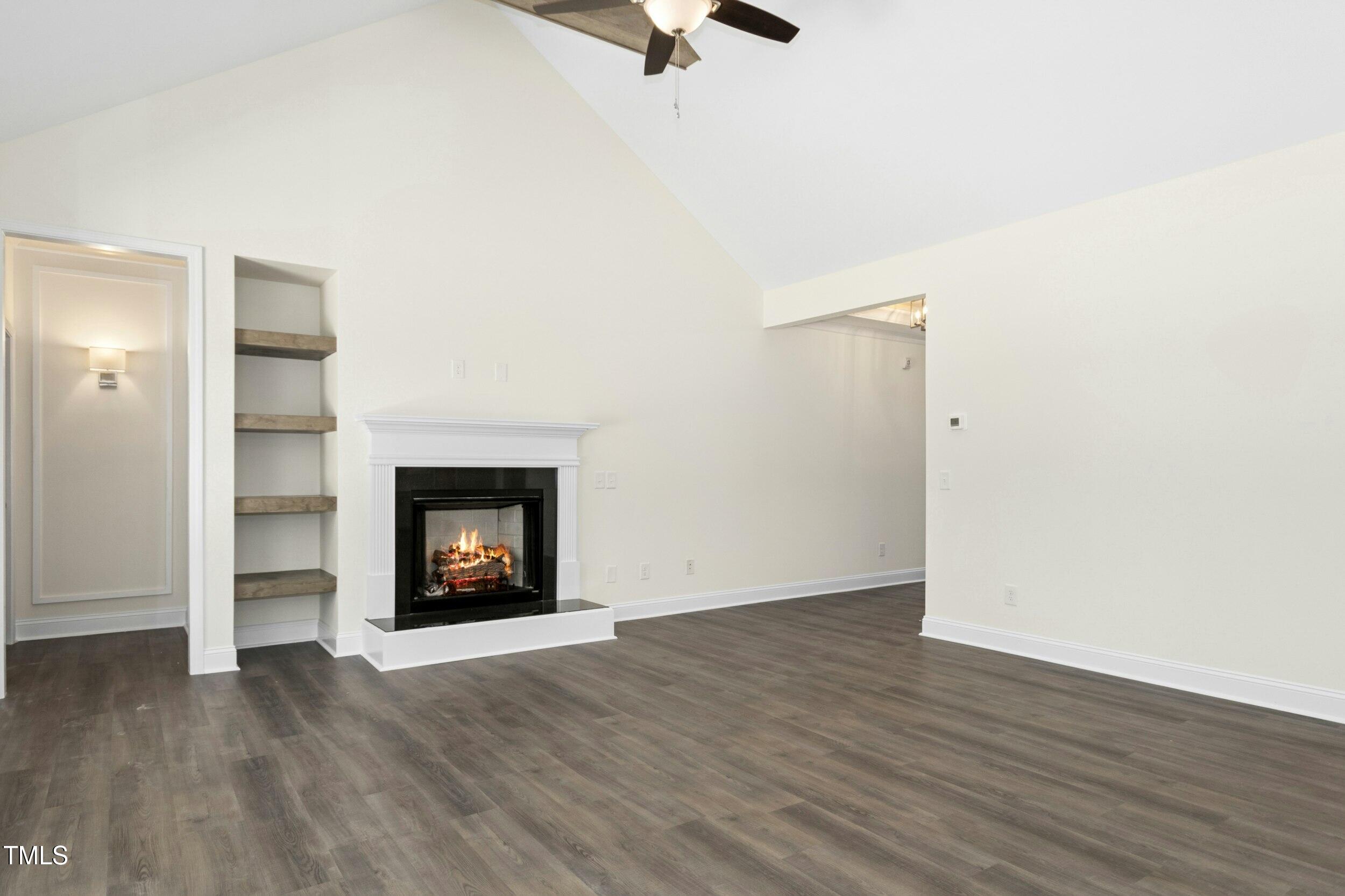 776 Shadetree Road Benson, NC 27504 - Photo 17 of 35 a view of an empty room with wooden floor fire place and a window