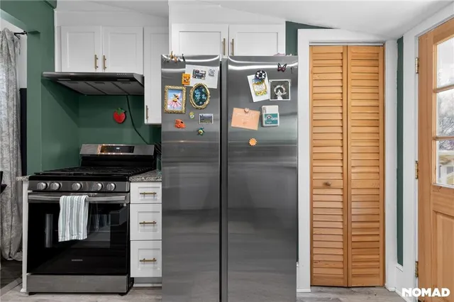 a kitchen with stainless steel appliances granite countertop a refrigerator sink and cabinets