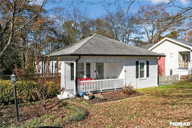 a front view of a house with a yard and potted plants
