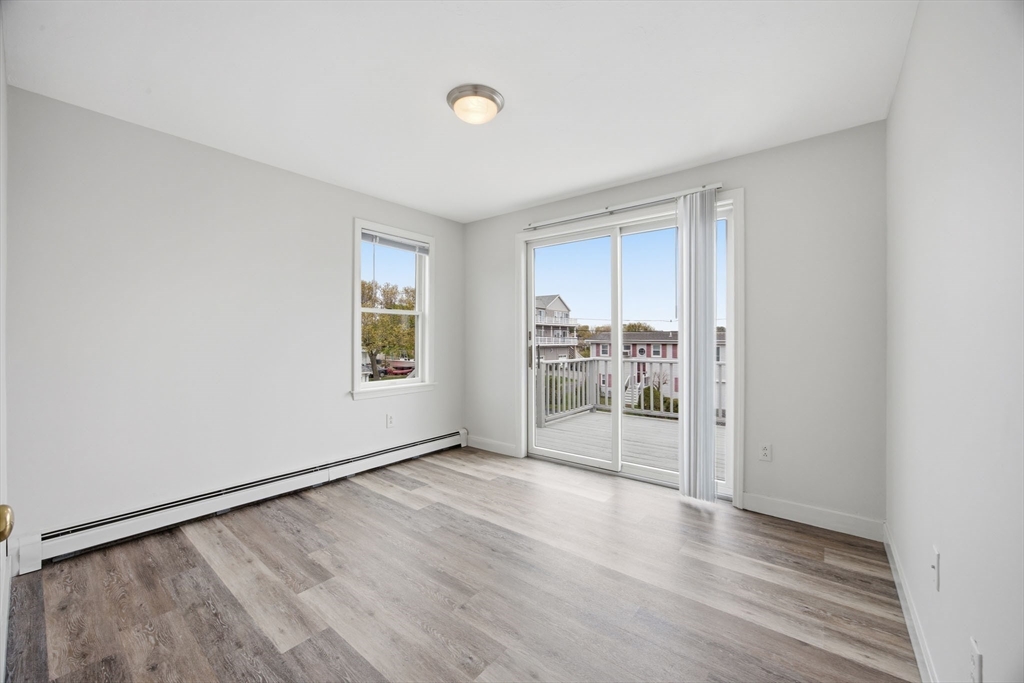 192 Swifts Beach Road Wareham, MA 02571 - Photo 35 of 38 an empty room with wooden floor and windows