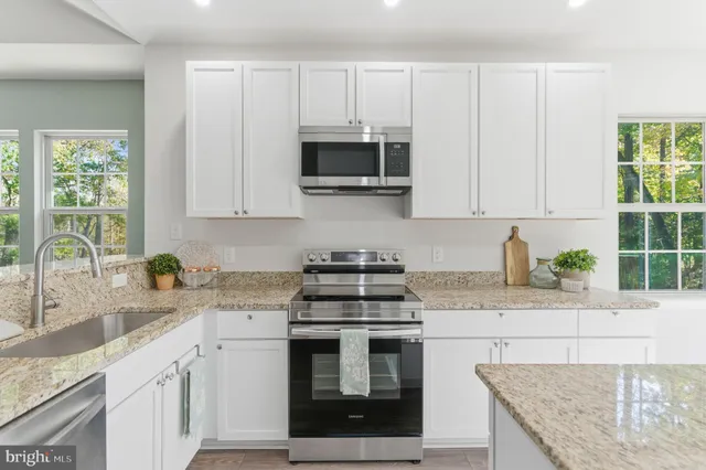 a kitchen with stainless steel appliances granite countertop a sink stove and cabinets