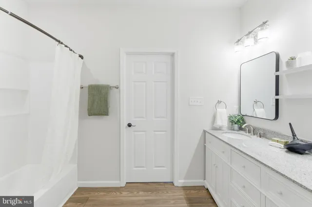 a bathroom with a granite countertop sink and a mirror