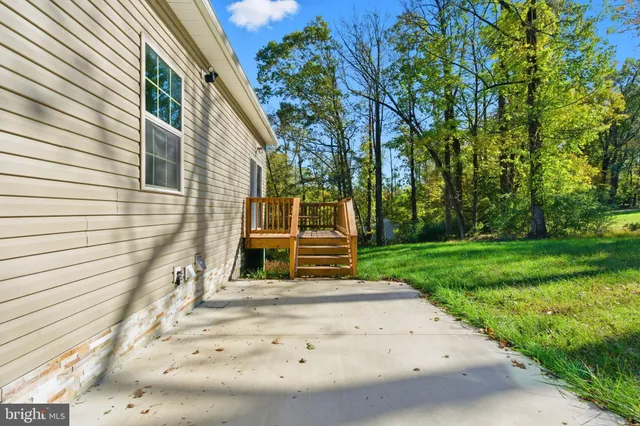 a view of a house with backyard and trees