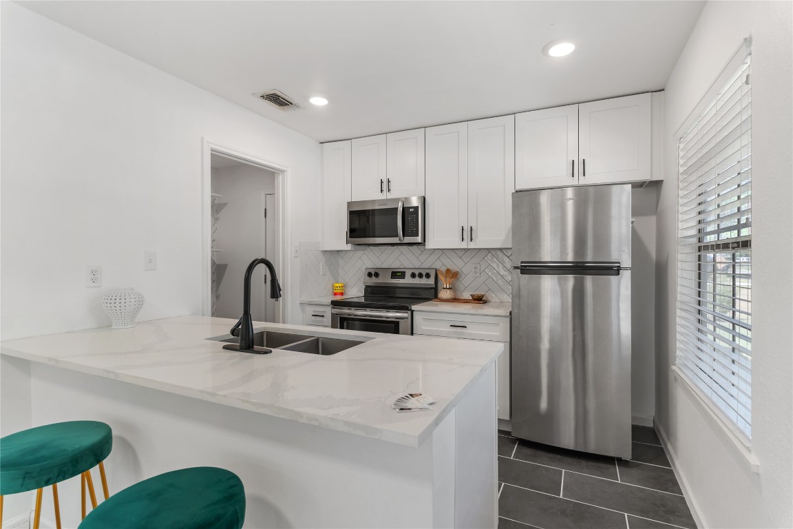 607 Magnolia Street Bastrop, TX 78602 - Photo 12 of 25 a kitchen with a refrigerator and a sink