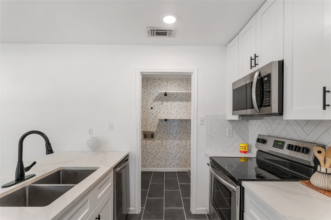 607 Magnolia Street Bastrop, TX 78602 - Photo 13 of 25 a kitchen with stainless steel appliances a stove a sink and a microwave
