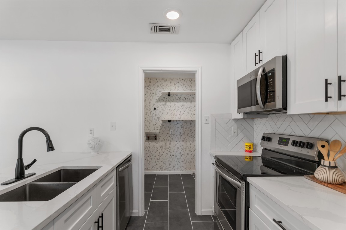 607 Magnolia Street Bastrop, TX 78602 - Photo 14 of 25 a kitchen with stainless steel appliances a stove a sink and a microwave