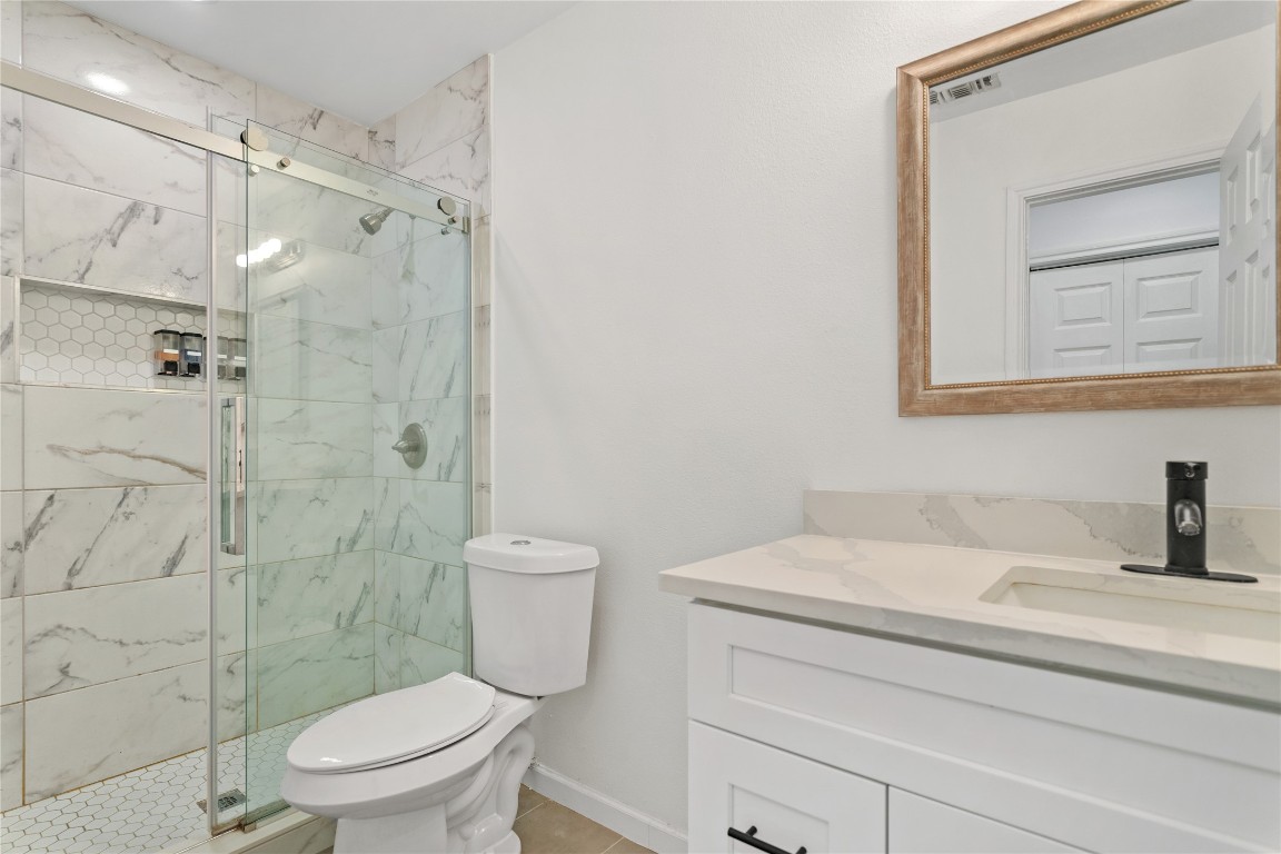 607 Magnolia Street Bastrop, TX 78602 - Photo 21 of 25 a bathroom with a sink a toilet and shower