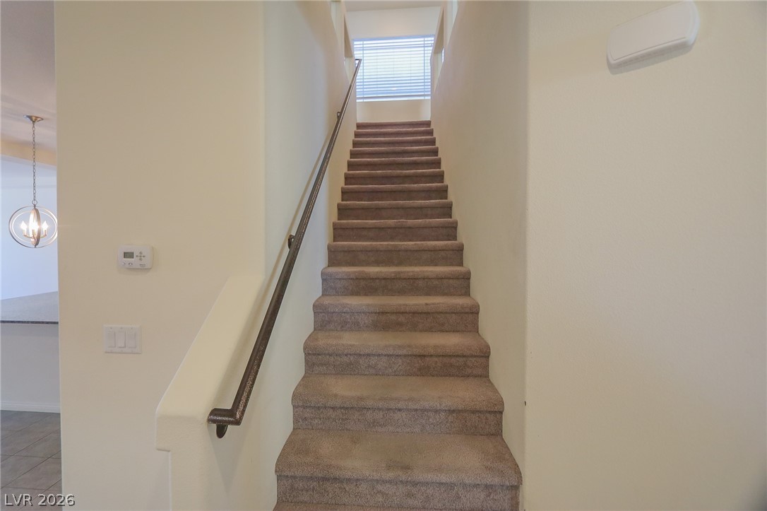 6418 Jackson Spring Road Las Vegas, NV 89118 - Photo 7 of 20 Carpeted stairs ascend to a sun-drenched landing, promising tranquil retreats.