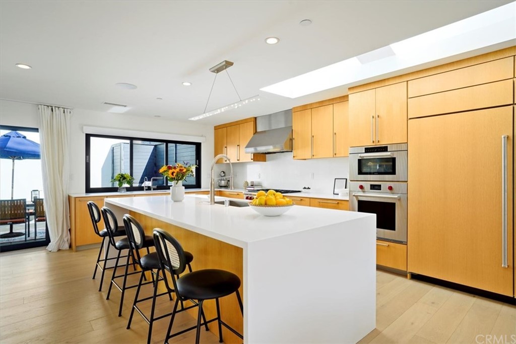 361 Aster Street Laguna Beach, CA 92651 - Photo 6 of 25 a kitchen with stainless steel appliances a stove a sink a refrigerator white cabinets and wooden floor