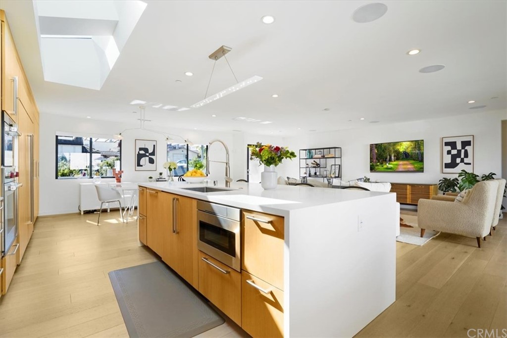 361 Aster Street Laguna Beach, CA 92651 - Photo 7 of 25 a kitchen with kitchen island sink stove and white cabinets with wooden floor
