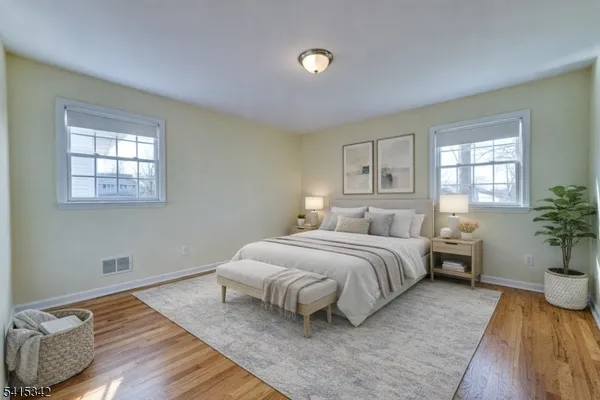 a spacious bedroom with a bed and wooden floor