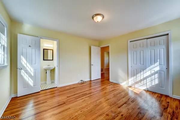 a view of a livingroom with wooden floor and a bathroom