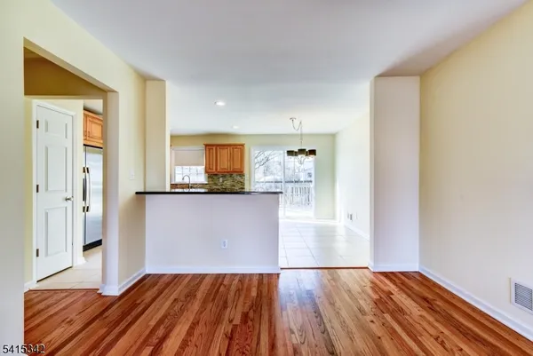 a view of a room with wooden floor and a kitchen