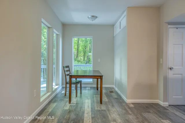 a view of a room with a window and wooden floor