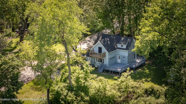an aerial view of a house with a yard and large trees