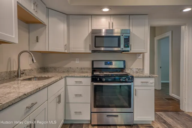 a kitchen with cabinets stainless steel appliances and a sink