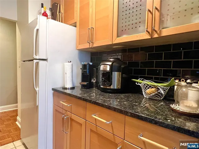 a kitchen with granite countertop a sink and a refrigerator