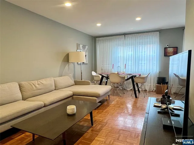 a living room with furniture a rug and a flat screen tv