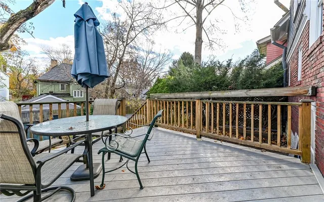 a balcony with wooden floor table and chairs