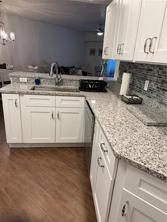 a kitchen with stainless steel appliances kitchen island granite countertop a refrigerator a stove and a sink
