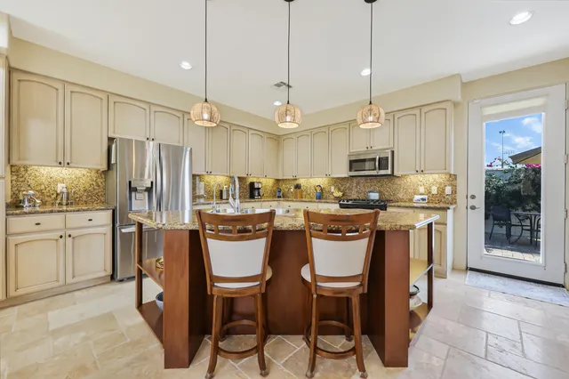 a kitchen with kitchen island granite countertop wooden cabinets and stainless steel appliances
