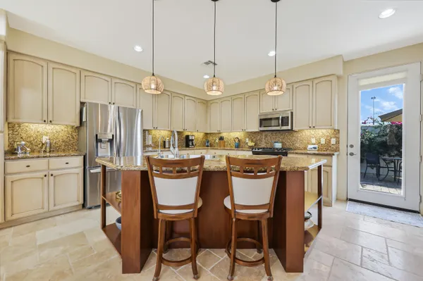 a kitchen with kitchen island granite countertop wooden cabinets and stainless steel appliances