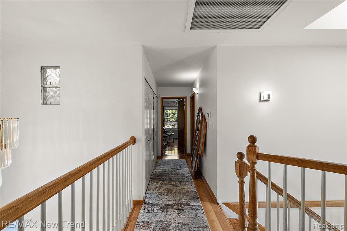 1450 Lenox Road Bloomfield Hills, MI 48304 - Photo 52 of 79 Hardwood flooring, wood railings with white balusters, glass block window, ceiling-mounted light fixture, and recessed lighting