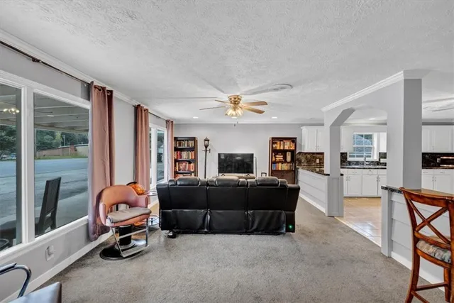 a living room with furniture and a kitchen view