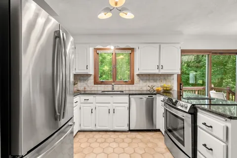 a kitchen with stainless steel appliances granite countertop a stove a sink and a refrigerator