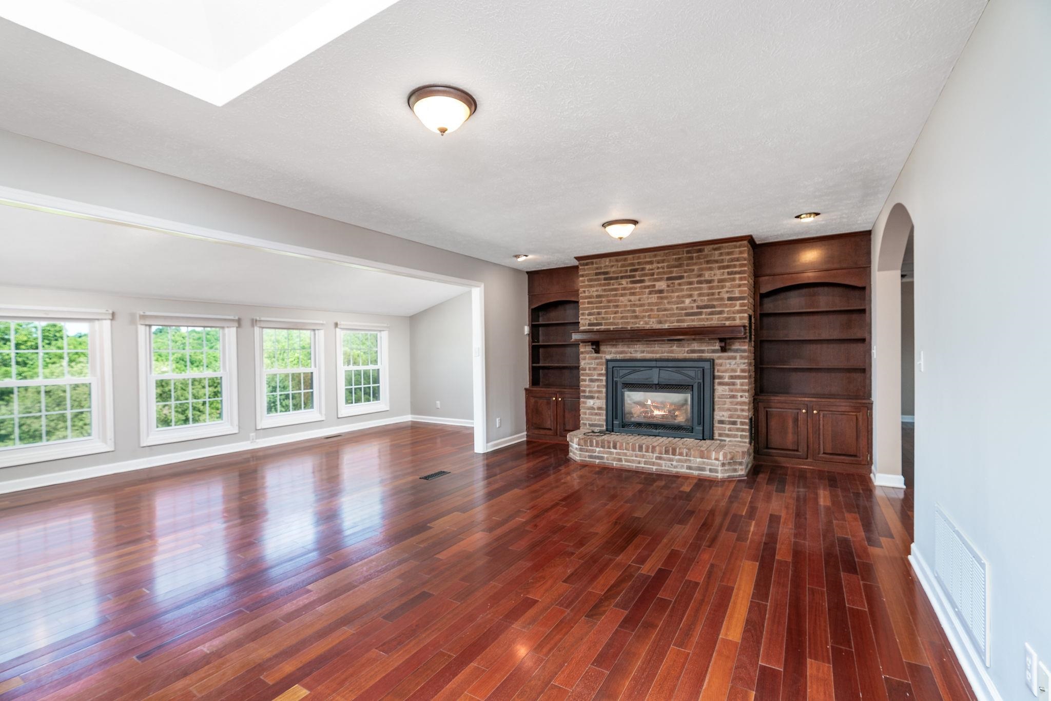 308 Stonewall Road Weyers Cave, VA 24486 - Photo 58 of 71 an empty room with wooden floor fireplace and windows