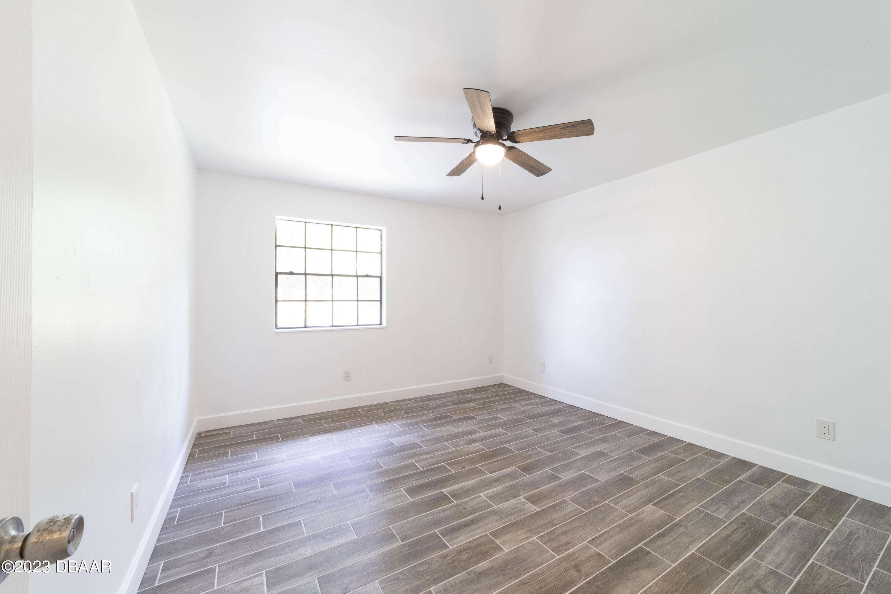 526 Live Oak Street, Unit 1050 Edgewater, FL 32132 - Photo 14 of 26 an empty room with wooden floor fan and windows