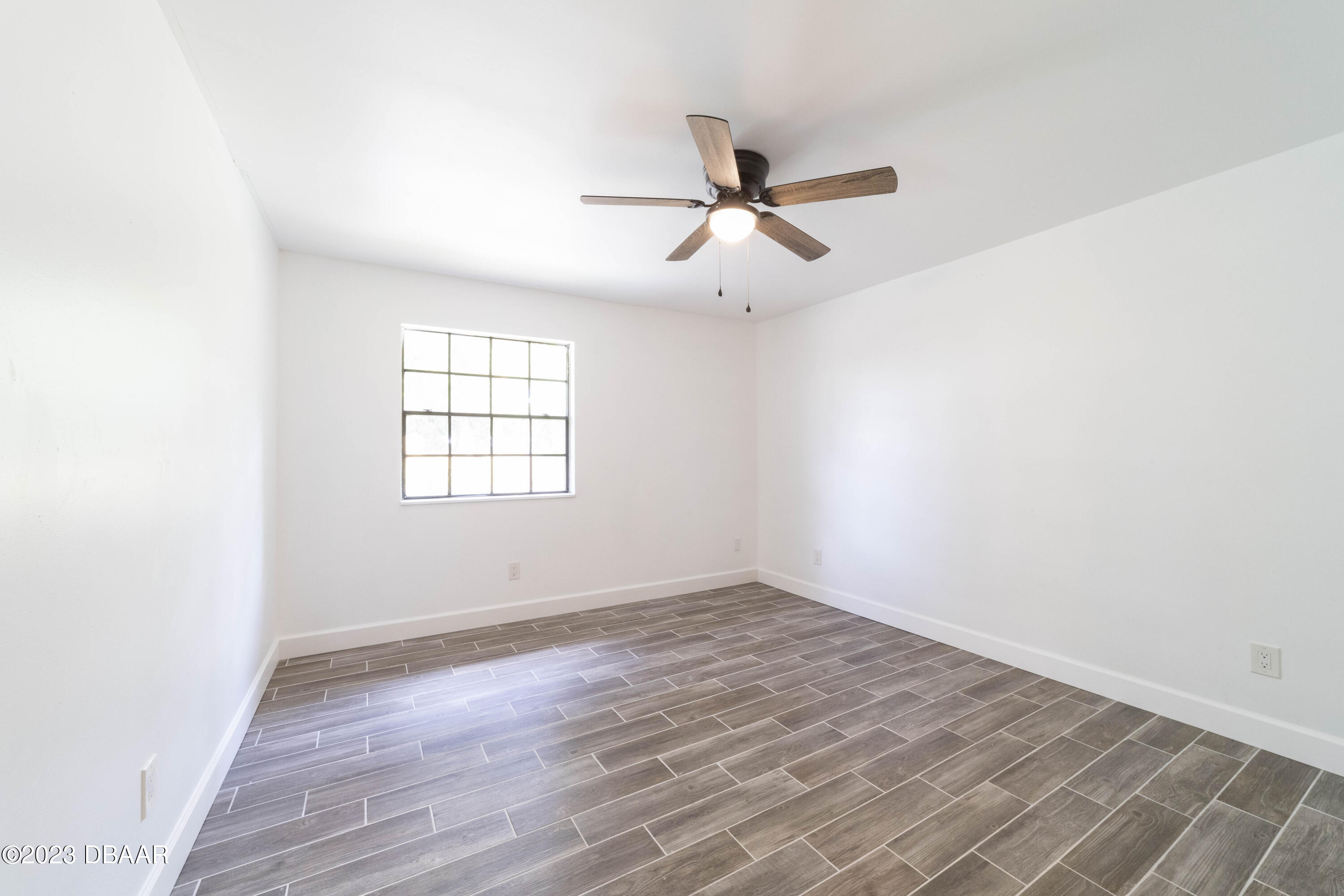 526 Live Oak Street, Unit 1050 Edgewater, FL 32132 - Photo 15 of 26 an empty room with wooden floor a ceiling fan and windows